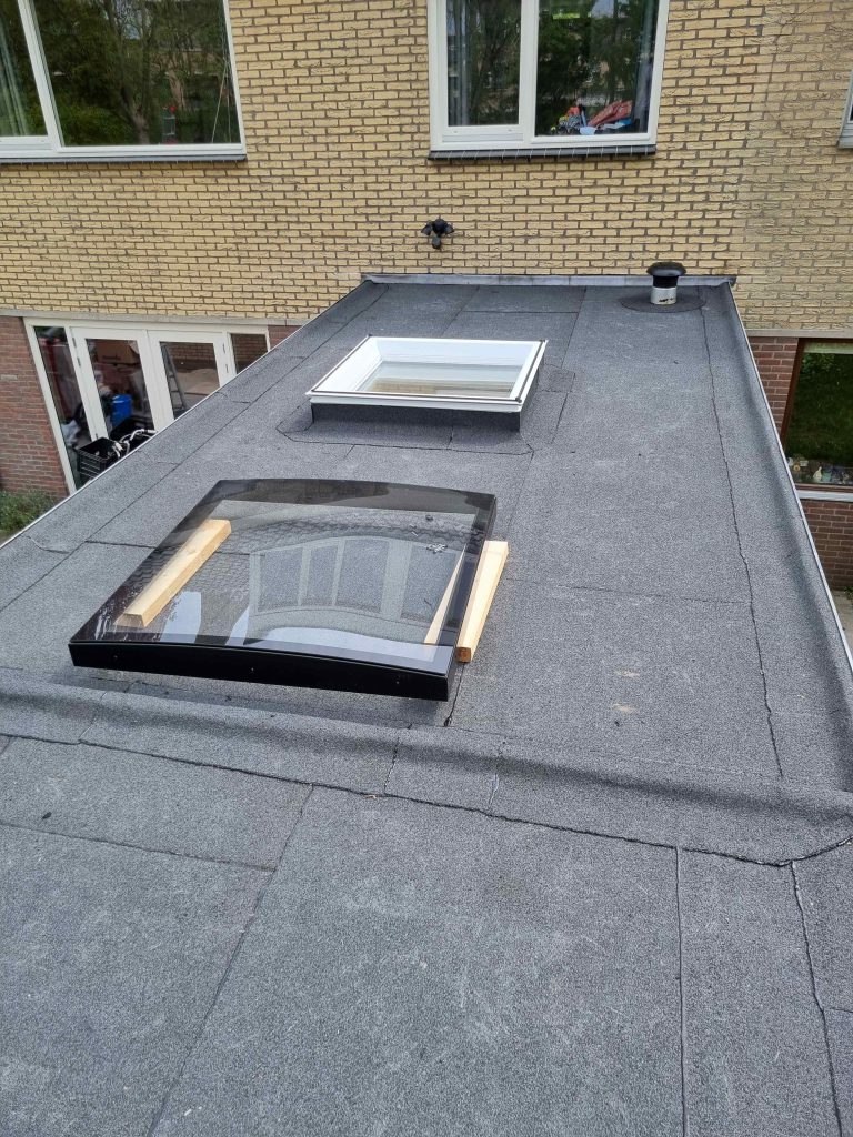 Nieuw bitumen dak op een aanbouw met lichtkoepel