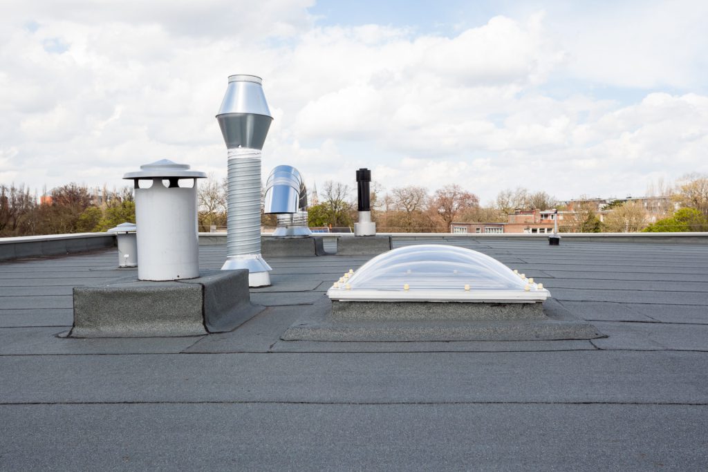 Nieuw bitumen dak met ingewerkte lichtkoepel en dakdoorvoeren